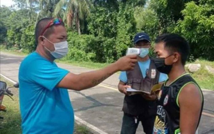 antique-village ONE ENTRY, ONE EXIT. A barangay official of Idio, Sebaste in northern Antique checks the body temperature of a resident at their “one entry, one exit” point. Barangay Idio chairperson Pamela Socorro Azucena says they are strictly limiting the movement of people to prevent the spread of coronavirus disease. PHOTO COURTESY OF LNB ANTIQUE