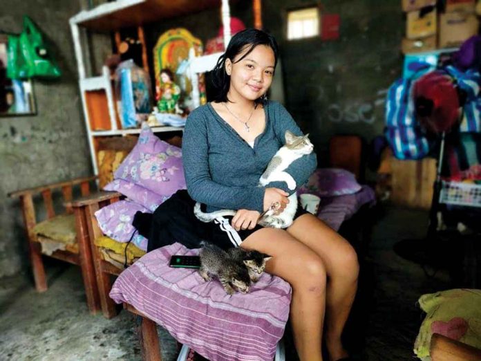 Marriel cradles one of her five cats. PANAY NEWS PHOTO