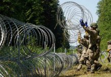 Lithuanian parliament to debate building fence on Belarus border Lithuanian army soldiers install razor wire on the border with Belarus in Druskininkai, Lithuania. REUTERS/JANIS LAIZANS