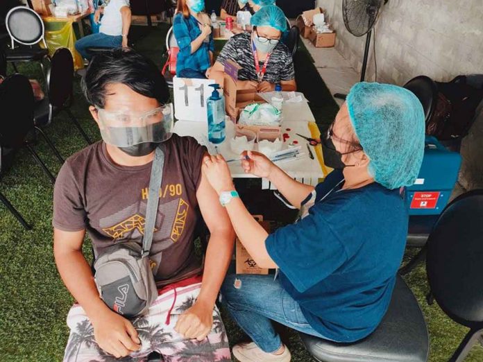 front-pic A health worker administers a dose of a vaccine against coronavirus disease 2019 (COVID-19) to this Iloilo City resident at the SM City Iloilo inoculation site. PANAY NEWS PHOTO