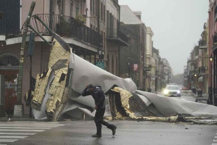 hurricane-ida A man passes by a section of the roof blown off of a building in the French Quarter in New Orleans by Hurricane Ida’s winds on Sunday. AP/ERIC GAY