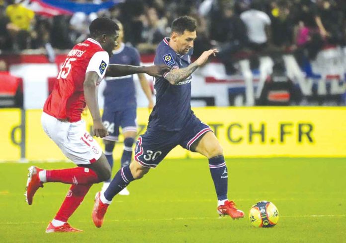 PSG's Lionel Messi (right) aims to get the ball against Reims' Marshall Munetsi during the French Ligue 1 football match between Paris Saint-Germain and Stade de Reims at the Stade Auguste-Delaune in Reims, France. AP/FRANCOIS MORI