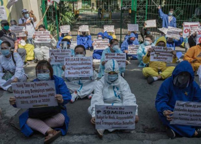 news-covid About 200 nurses and public health workers in protective suits stage a “sit-down protest’’ outside the Department of Health building in Manila on June 30, 2021, the day the Bayanihan 2 stimulus spending law lapsed. The workers are demanding the release of their benefits, including a monthly P3,000 COVID-19 hazard pay. INQUIRER/RICHARD REYES