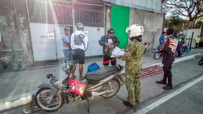 news-ruby-cops A police officer checks a motorist’s credentials along Muelle Loney Street, Iloilo City. Only essential travel is allowed at this time in the metro which is under an enhanced community quarantine due to the coronavirus pandemic. PANAY NEWS PHOTO
