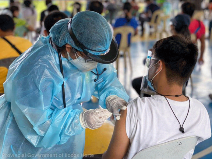 A health worker in Ilocos Norte province administers a COVID-19 vaccine to a resident. ILOCOS NORTE PROVINCIAL GOVERNMENT