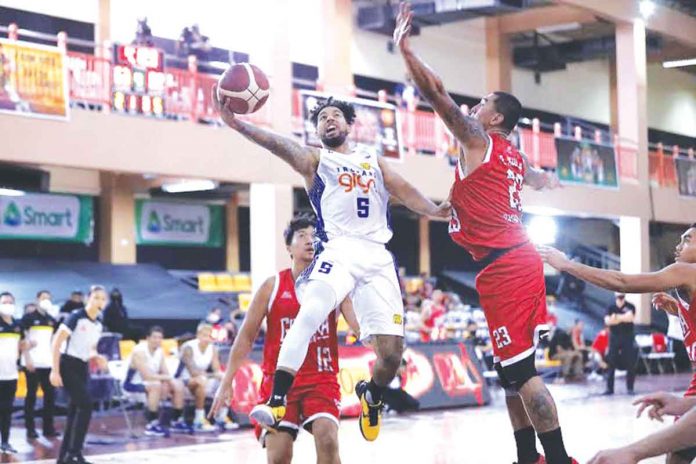 Mikey Williams (5) attempts to score for TNT Tropang Giga while Raymond Aguilar of Barangay Ginebra San Miguel Kings defends during Sunday night's PBA Philippine Cup match at the Don Honorio Ventura State University Gym in Bacolor, Pampanga. PBA Mikey Williams (5) attempts to score for TNT Tropang Giga while Raymond Aguilar of Barangay Ginebra San Miguel Kings defends during Sunday night's PBA Philippine Cup match at the Don Honorio Ventura State University Gym in Bacolor, Pampanga. PBA