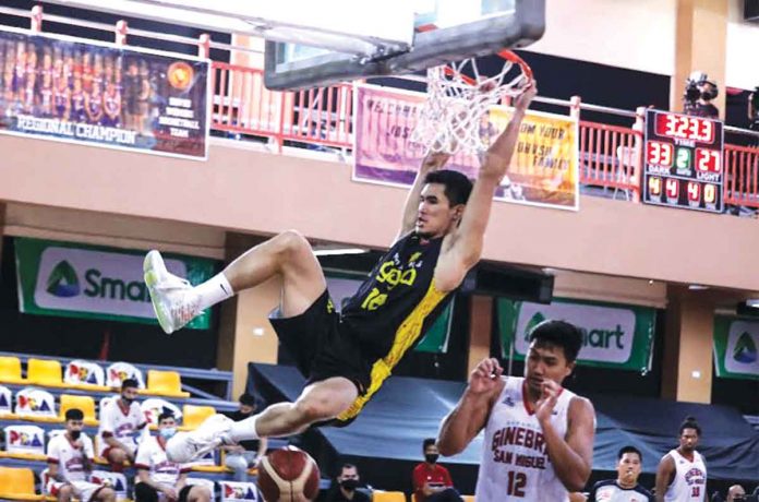 banner Jeth Troy Rosario of TNT Tropang Giga clutches the ring after converting a fast break two-handed dunk. Rosario scored 15 points in last night’s quarterfinals game against Barangay Ginebra San Miguel Kings. PBA