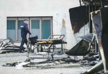 Blaze at COVID-19 field hospital kills 14 A police officer walks past burned hospital equipment on the site of a destroyed field hospital following a fire in Tetovo, North Macedonia. AP/VISAR KRYEZIU