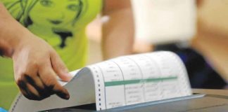A voter places her ballot in a PCOS machine after voting at precinct 169 of San Antonio High School in Makati City. According to Comelec, registered voters who are positive for COVID-19 can vote in the coming 2022 elections. INQUIRER/ARNOLD ALMACEN