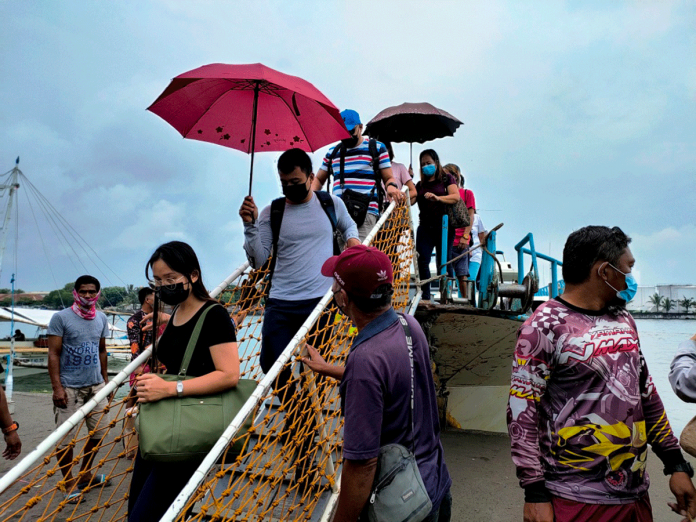 Passengers from the island province of Guimaras disembark from a motorboat at the Iloilo-Guimaras Ferry Terminal in Iloilo City. The provincial government of Guimaras is requiring all its job hires and applicants for job hire positions to get vaccinated against coronavirus disease 2019. PANAY NEWS PHOTO