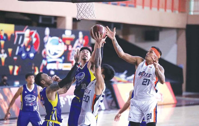 Magnolia Pambansang Manok Hotshots’ Ian Sangalang (center) battles for the rebound with Meralco Bolts’ Raymond Almazan (20) and Reynel Hugnatan (21). PBA MEDIA BUREAU