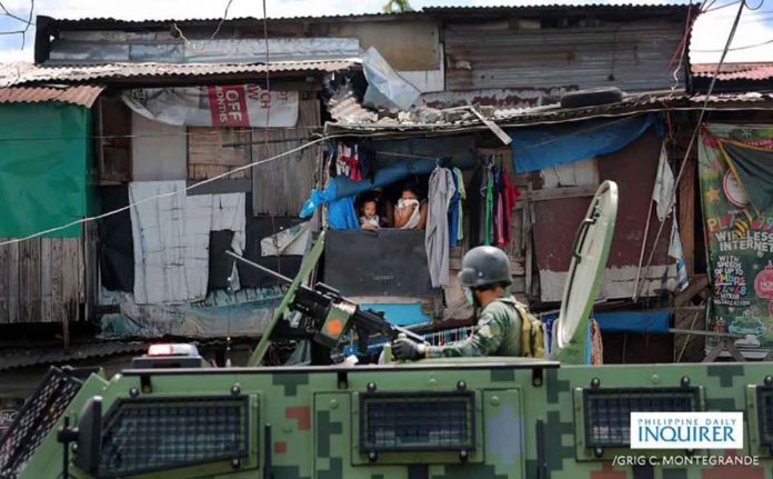 A Philippine National Police Special Action Force trooper sits on top of an armored personnel carrier which was deployed in Navotas City. The PNP is mulling to deploy police commandos of the SAF to maintain security and order during the election season. INQUIRER/GRIG C. MONTEGRANDE