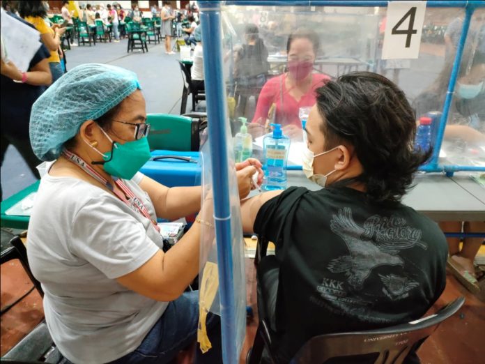 A teenager gets his first dose of the vaccine against coronavirus disease at the University of San Agustin gymnasium in Iloilo City NO PAIN, NO GAIN A teenager gets his first dose of the vaccine against coronavirus disease at the University of San Agustin gymnasium in Iloilo City. Over 3,000 minors aged 12 to 17 years old in the metro have so far been vaccinated against the viral disease. The city government’s pediatric vaccination roll-out started on Nov. 2, 2021. PANAY NEWS PHOTO