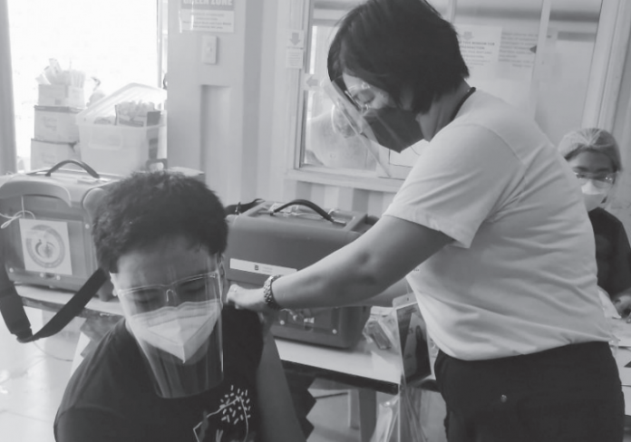 A youngster gets his first shot of the vaccine against coronavirus disease at the Roxas Memorial Provincial Hospital in Roxas City. PHOTO BY MERLINDA BAGNATE