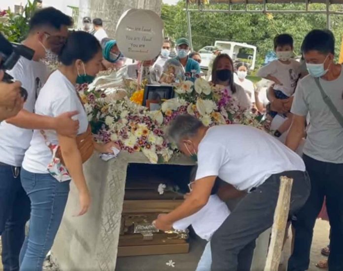 diergos Guided by her grandfather, Claire Diergos’ three-year-old daughter offers a flower to her dear mother during the latter’s interment on Sunday. Friends and family cry justice on her death. DYRI 774
