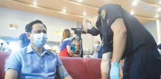 Iloilo’s Gov. Arthur  Defensor Jr. gets his blood pressure checked prior to receiving a Sinovac booster jab at the West Visayas State University Cultural Center. PANAY NEWS PHOTO