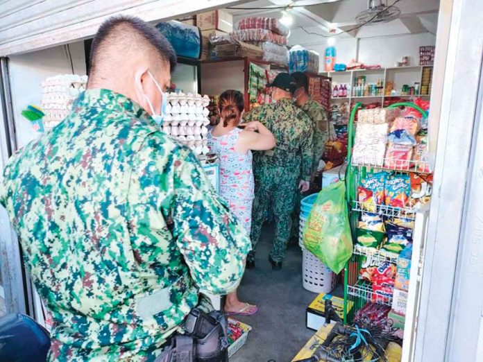 zarraga Policemen survey a store ransacked by robbers yesterday in Barangay Poblacion Ilawod, Zarraga, Iloilo. PANAY NEWS PHOTO