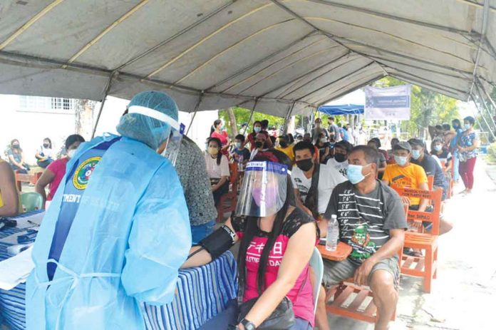 bayanihan A healthcare worker checks the blood pressure of a resident in the Rural Health Unit of Zarraga, Iloilo in the first “Bayanihan Bakunahan” national coronavirus disease 2019 vaccination days. PANAY NEWS PHOTO