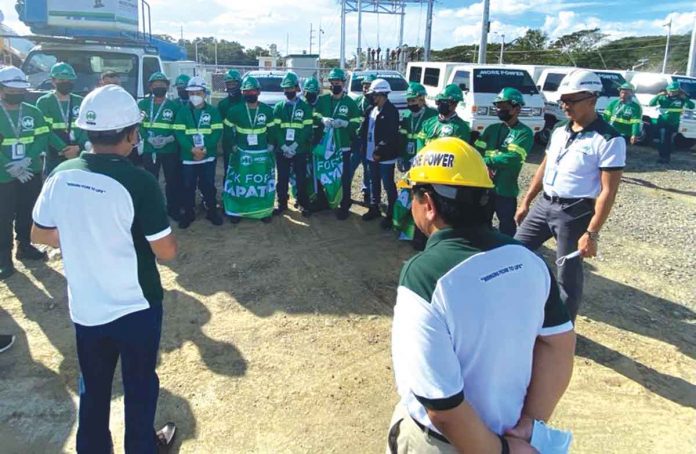 front-more-power-pic MORE Power president Roel Castro (right foreground, back facing the camera) gives a pep talk to his personnel before deploying them to Negros Island.