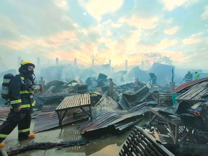 front-pic A firefighter surveys what’s left of the public market of Oton, Iloilo that fire gutted before dawn on Monday. The Bureau of Fire Protection’s initial estimate of the damage reached P44 million. PN PHOTO