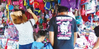 SIDEWALK SHOPPING. A young boy patiently waits for his Christmas present as his father and mother check this sidewalk stall for toys and other items in downtown Iloilo City. Early this December, the government kicked off the annual holiday campaign “Ligtas Christmas sa Healthy Pilipinas” to guide the public on easy and doable ways to safely celebrate the holiday season. PN PHOTO
