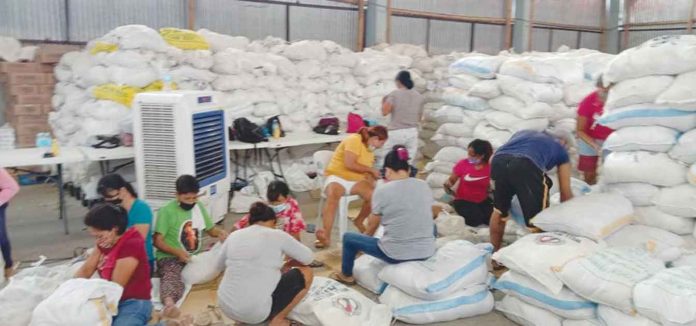 gift Sacks of rice are being repacked for distribution to identified beneficiaries – indigent families, senior citizens and persons with disabilities – of the Iloilo City government's yearly gift-giving. MAYOR JERRY TREÑAS FB PAGE