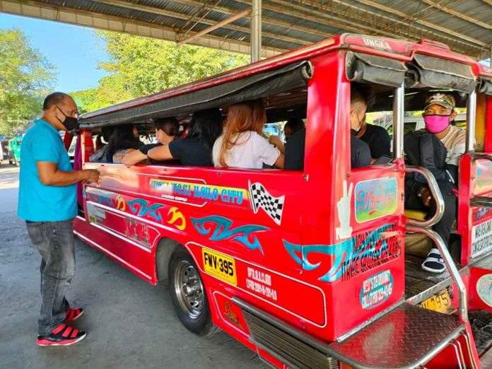 ungka-jeepney A jeepney driver collects fare from passengers at the transport terminal in Barangay Ungka, Jaro, Iloilo City. PANAY NEWS