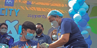 A youngster avails himself of an anti-coronavirus vaccine on the first day of the “Bayanihan Bakunahan” national vaccination drive at SM City Iloilo. PANAY NEWS PHOTO