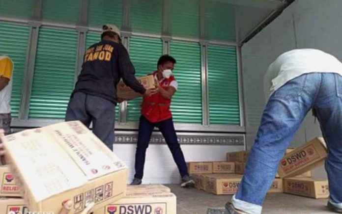 evac Department of Social Welfare and Development personnel are seen at the repacking and preposition site in Dumarao, Capiz carry family food packs for transport to Dao, Capiz and Negros Occidental. PHOTO COURTESY OF ARNULFO LEAL, DSWD-6