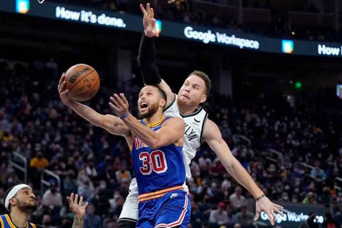 sports-curry-pic Golden State Warriors’ Stephen Curry goes under the defense of Brooklyn Nets’ Blake Griffin for an inside basket. AP PHOTO
