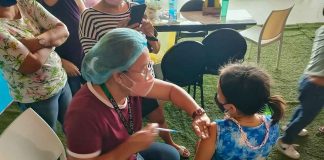 BRAVE GIRL. A young girl stays still while being vaccinated against coronavirus disease 2019 at SMs City Iloilo in Mandurriao district. PH PHOTO