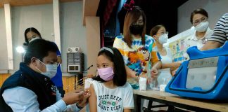 A young girl stays calm while being vaccinated against coronavirus disease by Dr. Adriano Suba-an, director of the Department of Health – Region 6, at the West Visayas State University Cultural Center, one of several vaccination sites of the provincial government of Iloilo. PN PHOTO
