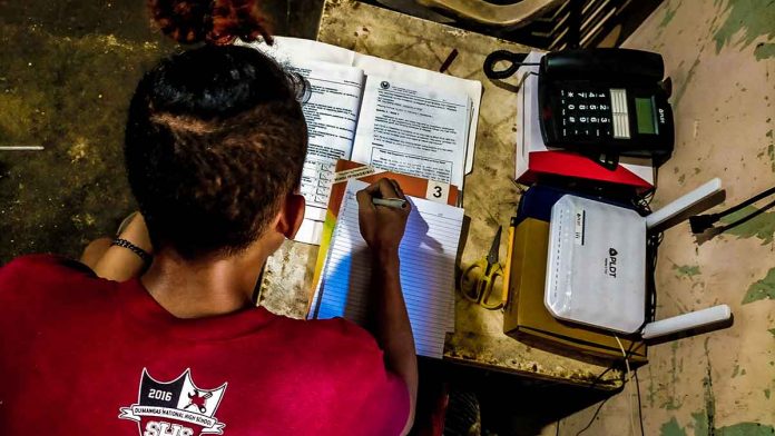 front-pic LEARNING KNOWS NO BOUNDARIES. A high school student answers his learning modules at home in Iloilo province. His school is not among those allowed to hold limited face-to-face classes. School Year 2021-2022 officially started on Aug. 5, 2021 and would end on June 24, 2022. The Department of Education will be allowing limited face-to-face graduation, too. PN PHOTO