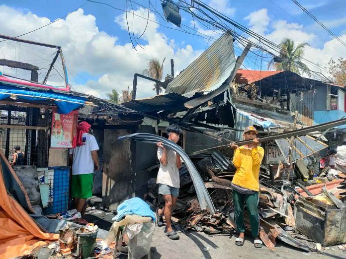 news-city-govt-to-relocate-pic Fire victims salvage whatever materials they could still recycle from what remains of their houses that fire gutted in Barangay Old Airport, Mandurriao, Iloilo City on March 11, 2022. According to the City Social Welfare and Development Office, 45 houses were totally razed while 18 were partially damaged. PN PHOTO