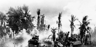 Troops of the 185th Infantry, 40th Division, take cover behind advancing tanks while moving up on Japanese positions on Panay Island. This is one of the shots salvaged from the camera of Lieutenant Robert Fields who was killed in action shortly after it was taken. PHOTO FROM WIKIPEDIA