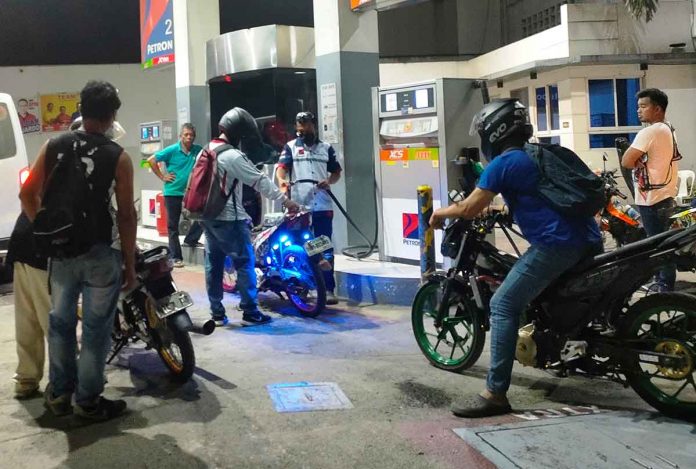news-ime-another-round Motorcycle riders wait for their turn to refuel at a gas station in Pavia, Iloilo on Friday night, hours before another round of fuel price increase takes effect. PN PHOTO