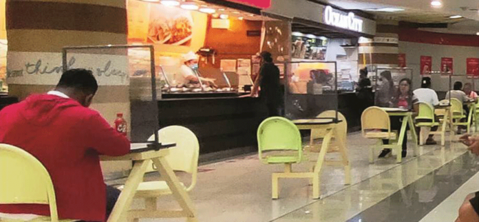 news-ime-plastic Every table in mall food court in Iloilo City has a plastic barrier to supposedly protect diners from coronavirus disease 2019. Plastic barriers also separate food kiosk cashiers from customers. PN PHOTO