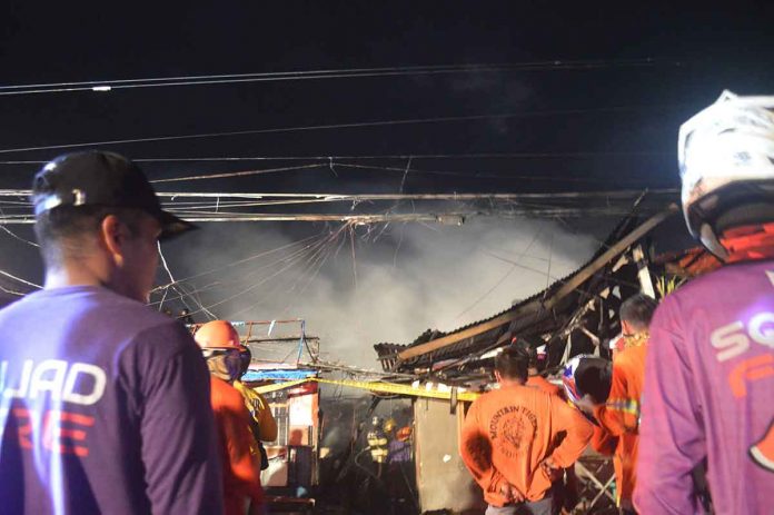 page2-pic Firefighters and rescuers stand before fire-gutted houses in Barangay Old Airport, Mandurriao, Iloilo City on March 11, 2022. PN PHOTOS