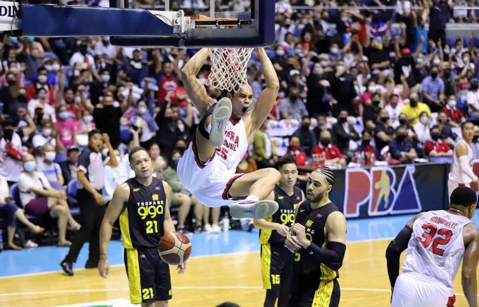 sports-ginebra-pic Barangay Ginebra San Miguel Kings’ Japeth Aguilar hangs to the ring after a two-handed dunk. PBA MEDIA BUREAU