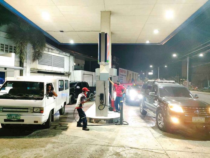 vehicles-gas-station Vehicles in Iloilo City are waiting for their turn to refuel at a gas station on Monday night, hours before another round of fuel price increase will take effect. PN PHOTO