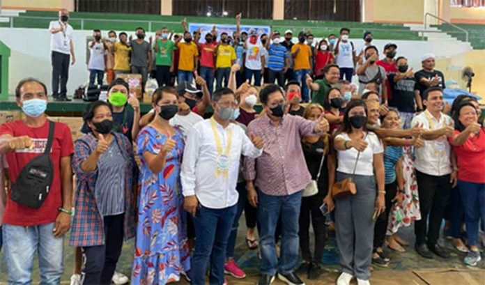 Secretary Silvestre H. Bello III (5th from left) and Department of Labor and Employment 6 (DOLE-6) Regional Director Atty. Sixto T. Rodriguez, Jr. pose with the beneficiaries after the turn-over of checks and project inputs during the Capiztahan Festival in Roxas, City.