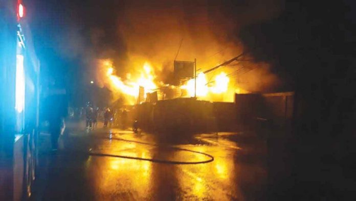 BURNING IN THE DARK. Fire strikes a neighborhood in Barangay 2, Bacolod City before dawn on April 8, 2022 – the second fire incident in the village in just three days. The area is no stranger to fires. In 2019, more than 200 houses were destroyed by fire there. BFP-BACOLOD PHOTO