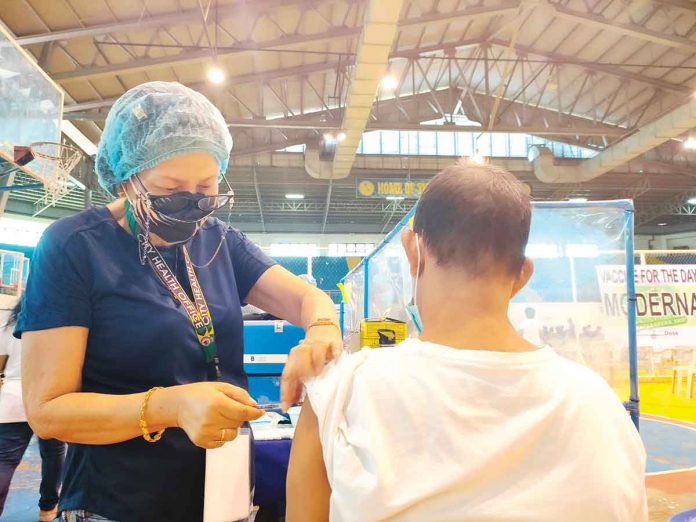 front-pic A resident of Iloilo City gets his shot of the vaccine against coronavirus disease 2019 at the covered gym of Central Philippine University, one of several vaccination sites of the city government. Based on government guidelines, COVID-19 booster shots may be given to adults at least three months after the second dose of a two-dose vaccine, or at least two months after the administration of a one-dose vaccine. PN PHOTO