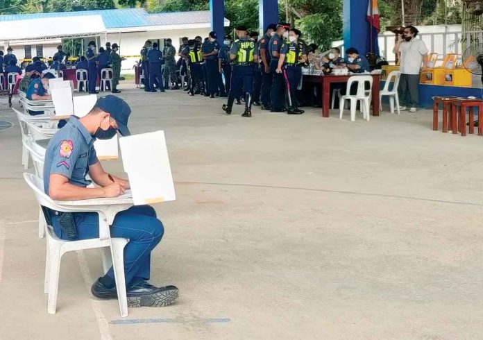 front-pic RIGHT TO VOTE. A policemen fills out his ballot at the Iloilo Police Office in Santa Barbara, Iloilo during the first day of the three-day local absentee voting for the May 9 elections. PHOTO BY GEOVANNI FAJARDO