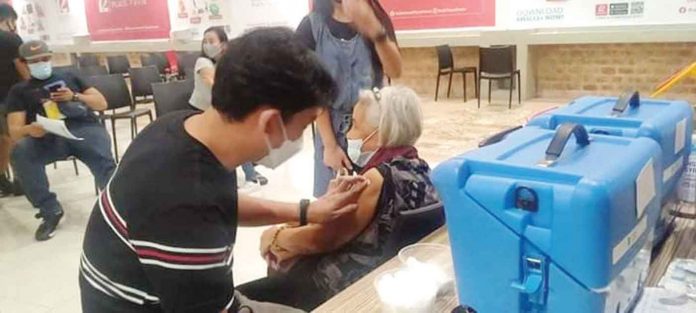front-pic A senior citizen is assisted by relatives after getting her shot of the vaccine against coronavirus disease at a mall in Pavia, Iloilo. The provincial government of Iloilo has taken its vaccination drive to the malls to increase the province’s inoculation rate, especially among the elderly. ILOILO PROVINCIAL HEALTH OFFICE PHOTO