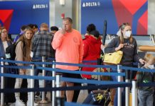 US DOJ to appeal ruling ending mask mandates on public transport Travelers wearing masks and not wearing masks wait in line at a Delta Airlines counter at the Logan International Airport in Boston, Massachusetts, U.S., April 19, 2022.