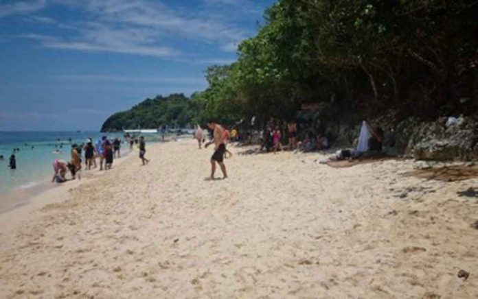 Tourists enjoy the white beach of Boracay Island during Holy Week before the pandemic in 2020. The Department of Tourism said the island should observe the 19,215 daily visitors while its 2018 carrying capacity study is being reviewed by the Department of Environment and Natural Resources. PNA FILE PHOTO