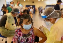 A medical worker administers a dose of the AstraZeneca vaccine against the coronavirus disease (COVID-19) to a woman at a stadium in New Taipei City, Taiwan June 25, 2021. REUTERS