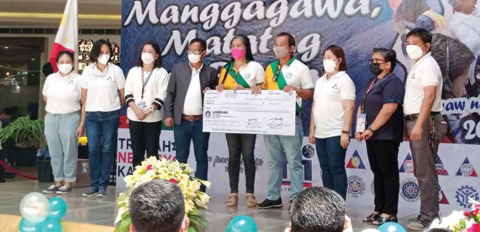 biz-glenda Members of the Batad Multi-Purpose Cooperative headed by Cesar Lariza receives a ceremonial check from the Department of Labor and Employment - Region 6 director Atty. Sixto Rodriguez. GLENDA TAYONA/PN