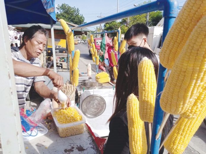 gdp A vendor sells corn in Barangay Baluarte, Molo, Iloilo City. Thanks to the easing of pandemic restrictions, he could now resume his humble business. In a statement, the country’s economic managers say many jobs and livelihood were restored “by shifting to a more endemic mindset, accelerating vaccination, and implementing granular lockdowns that only targeted the areas of highest risk while allowing the majority of our people to work and earn a living.” PHOTO BY IME SORNITO